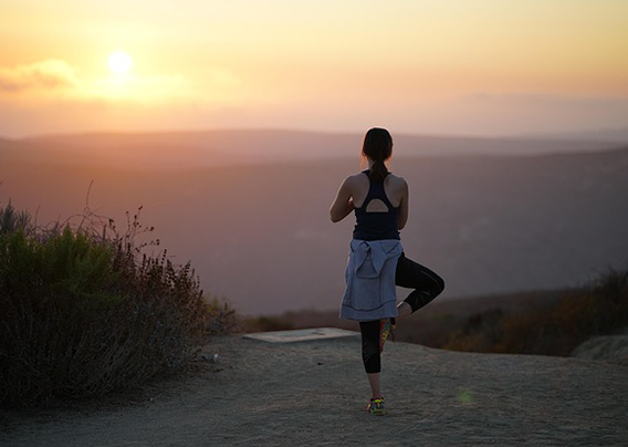 Woman performing standing yoga position on one leg.